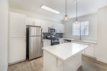 A renovated kitchen with white cabinets and stainless steel appliances